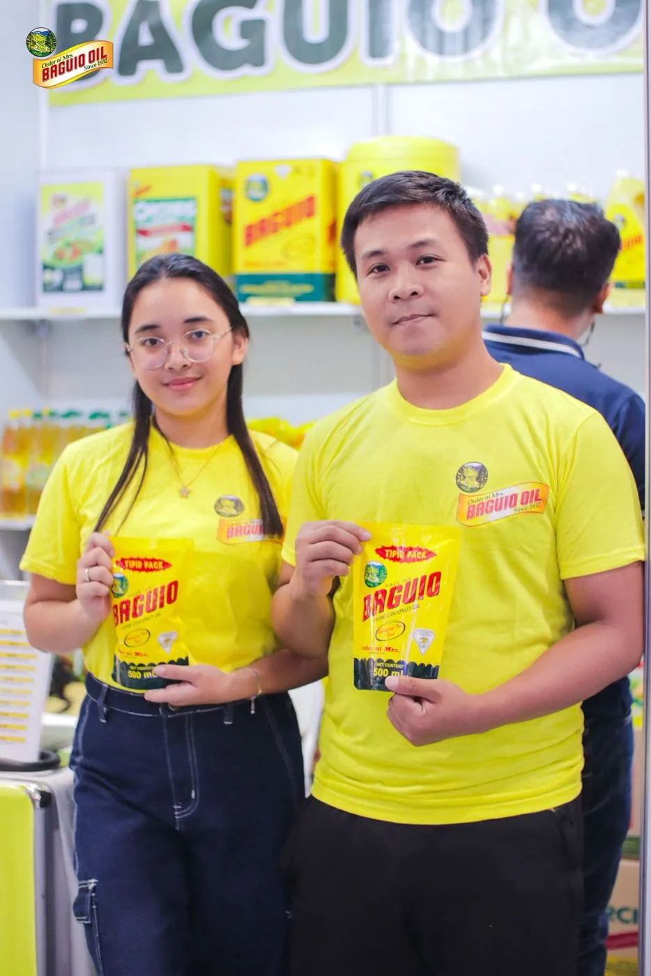 Baguio Oil staff holding product pouches at DTI 2024